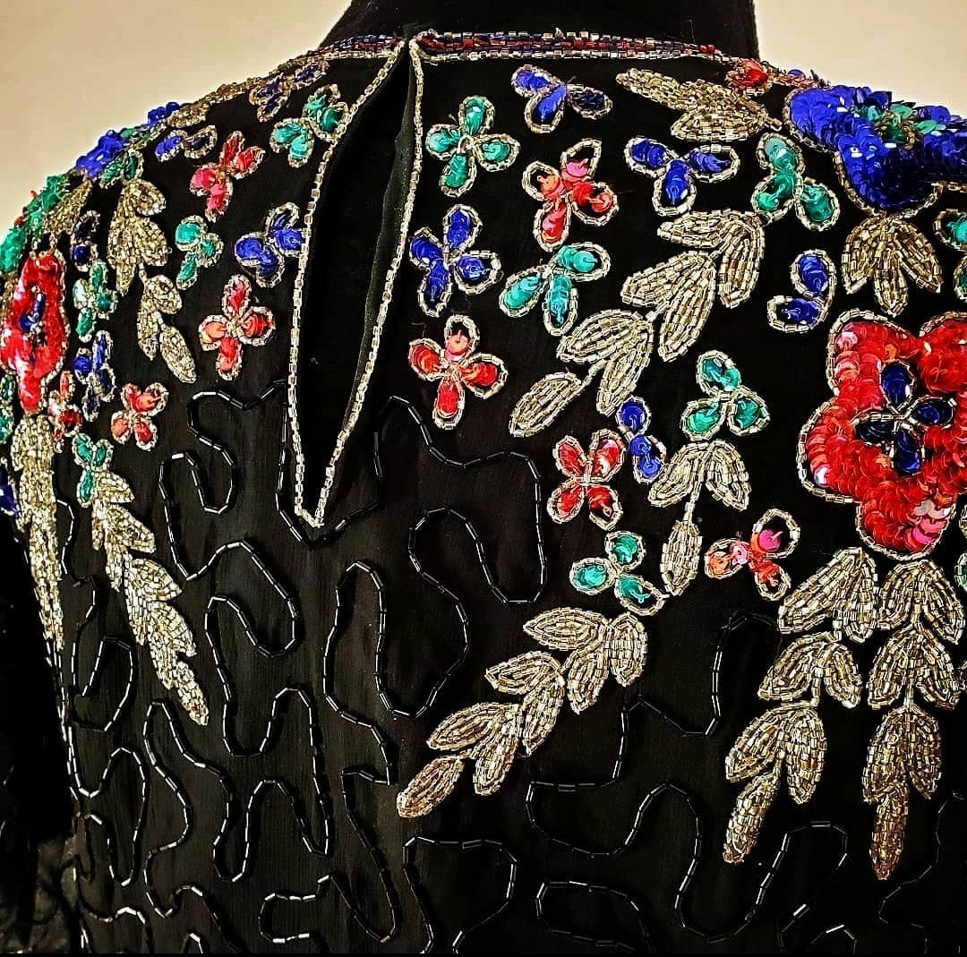 close up view of back of 80s top with flower adorned beaded top